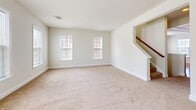 Located at 124 Cabot Alley in Mechanicsburg, Pennsylvania, this three-bedroom, two-bathroom residence is thoughtfully organized across three floors. The ground level features a garage with a concrete floor and standard overhead door, providing secure parking and additional storage space.

The main living floor offers a generously sized open layout with plush carpeting, multiple windows that draw in natural light, and a staircase with a wood railing. The kitchen is a standout feature, showcasing rich cherry wood cabinetry with crown molding detail, a large granite-topped island with a built-in sink, hardwood flooring, and black Whirlpool appliances including a side-by-side refrigerator, electric range, and over-the-range microwave.

The upper floor houses all three bedrooms, including a spacious primary bedroom with a walk-in closet fitted with wire shelving systems. The additional bedrooms feature plush carpeting and double-door closets. Two full bathrooms serve the upper level, each equipped with a tub-shower combination and clean, neutral finishes. Throughout the home, neutral wall tones and consistent trim work create a cohesive and functional living environment.