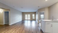 Located at 210 Summit Blvd in Broomfield, Colorado, this well-appointed 2-bedroom, 2-bathroom single-floor residence offers a thoughtfully designed layout with contemporary finishes throughout. The open living room is bright and generously sized, featuring rich hardwood-style flooring, neutral warm-toned walls, and French doors that invite abundant natural light. The modern kitchen is a standout, showcasing white cabinetry, light quartz countertops, a subway tile backsplash, stainless steel appliances including a range, microwave, and refrigerator, and a deep undermount sink. The spacious primary bedroom offers plush carpeting and a ceiling fan, complemented by a large walk-in closet with wire shelving for ample storage. The second bedroom is equally comfortable with carpet and a ceiling fan. Both bathrooms are clean and functional, featuring white vanities with quartz countertops, large mirrors, and hardwood-style flooring. A dedicated in-unit laundry room accommodates a full-size washer and dryer. With four closets total and a practical hallway connecting all rooms, this residence delivers excellent storage and flow throughout its well-utilized single-floor footprint.