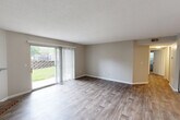 Located at 1269 Mangrove Ln in Saint Louis, MO, this single-floor, 3-bedroom, 2-bathroom home offers a practical and comfortable layout. The living room is a highlight of the space, featuring durable hardwood-style flooring, a textured ceiling, and large sliding glass doors fitted with vertical blinds that open to a view of the outdoors, filling the room with natural light. A brick-accented fireplace adds a classic touch to the adjoining area, which also connects to the kitchen.

The kitchen is designed with functionality in mind, boasting a breakfast bar with seating, light-toned cabinetry, dark lower cabinets, and ample counter space. A ceiling fan overhead and convenient in-unit washer and dryer access enhance everyday living.

The three bedrooms are carpeted and each features windows that bring in natural light and outdoor greenery views. The spacious primary bedroom offers a comfortable retreat. The two bathrooms are well-appointed — one features a walk-in glass-enclosed shower with a modern vanity and wood-look tile flooring, while the second includes a shower-tub combo with clean, bright finishes. A connecting hallway ties the layout together cohesively throughout the home.