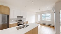 Located at 110 Lucas St NW in Calgary's growing Lucas neighbourhood, this one-bedroom, one-bathroom unit offers a thoughtfully designed single-floor layout with a clean, contemporary aesthetic throughout.

The open-concept kitchen and living area serves as the heart of the unit. The kitchen is outfitted with warm wood-tone cabinetry paired with crisp white upper cabinets and a matching white quartz countertop. A central island with an undermount double sink provides additional workspace and a natural gathering point. Stainless steel appliances, including a French-door refrigerator and electric range, complete the modern finish. Light hardwood flooring runs throughout the space, enhancing the bright and airy atmosphere.

The bedroom offers a comfortable, well-proportioned retreat with clean white walls and a baseboard heating system. The four-piece bathroom features a full soaker tub and shower combination with neutral tile surrounds and polished chrome fixtures. A dedicated in-suite laundry closet houses a stacked front-load washer and dryer, adding everyday convenience.

A private balcony overlooks the surrounding streetscape of the newly developing Lucas community, offering views of the neighbourhood's modern townhomes and streets. The unit combines functional design with quality finishes, making it a practical and attractive home in northwest Calgary.