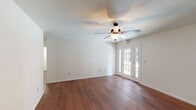 Located at 7278 Norwood Ct in Norwood Court, MO, this single-floor residence offers a well-organized layout with consistent, warm hardwood-style flooring running throughout every room. The spacious living area is a standout feature, highlighted by a ceiling fan with integrated lighting and elegant French doors that invite natural light and provide access to the exterior. The open feel of this room is further enhanced by clean white walls and generous proportions.

The galley-style kitchen is well-appointed with rich, dark espresso cabinetry, granite-look countertops, and a full suite of black appliances including a refrigerator, electric range, microwave, and sink — offering a practical and cohesive cooking space.

The bedrooms continue the hardwood-style flooring and are each equipped with ceiling fans or overhead lighting and windows fitted with vertical blinds for privacy and light control. The primary bedroom features dual closets and direct access to a private bathroom.

The bathroom includes a clean white vanity with a large mirror, dark wood cabinetry, and a full tub-shower combination. The overall aesthetic throughout the unit is neutral and move-in ready, with white walls and classic trim creating a bright, versatile backdrop suitable for a variety of interior styles.