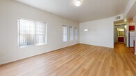 Located at 825 N 6th Ave in Phoenix, Arizona, this single-floor, 3-bedroom, 2-bathroom home offers a practical and comfortable layout. The spacious living room greets you upon entry, featuring light wood-tone flooring, crisp white walls, and multiple windows dressed with vertical blinds that allow ample natural light to fill the space. A pendant light fixture adds a subtle design touch overhead.

The kitchen is well-appointed with warm wood cabinetry extending to the ceiling, white countertops, a double-basin sink, and white appliances including a dishwasher, electric range, and over-the-range microwave. Light wood flooring continues seamlessly from the main living areas into the kitchen.

The three bedrooms are carpeted in a neutral tan tone and feature vertical blinds on windows that bring in natural light. The primary bedroom offers a cozy, quiet retreat. A carpeted hallway with classic six-panel doors connects the bedrooms to the rest of the home.

Both bathrooms are finished with wood-toned vanities, white countertops, and mirrors. One bathroom features a full tub-shower combo with chrome fixtures and light wood flooring, maintaining a clean and consistent aesthetic throughout. Overall, the home presents a bright, neutral palette ideal for easy personalization.