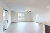 Located at 629 Old Liverpool Rd in Liverpool, NY, this well-designed 2-bedroom, 1-bathroom residence offers a thoughtful single-floor layout that maximizes comfort and functionality. The open-concept living and kitchen area serves as the heart of the home, featuring light wood-style flooring, crisp white walls, and a ceiling fan that enhances the bright, airy atmosphere. Natural light pours in through large windows, and a glass-paneled door provides access to an outdoor deck. The kitchen is outfitted with rich dark cabinetry, granite countertops, stainless steel appliances including an electric range and over-the-range microwave, and matching wood-style flooring that ties the space together seamlessly. Both bedrooms are carpeted for warmth and comfort, each featuring ceiling fans and windows with outdoor views. The spacious primary bedroom includes a generous walk-in closet with wire shelving systems offering ample storage. The full bathroom is clean and modern, featuring a combination tub and shower with sliding glass doors, light flooring, and accessibility-friendly grab bars. A dedicated laundry area with a full-size Whirlpool washer and dryer adds everyday convenience to this well-appointed residence.