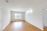 Located at 130 Rollins Ave in Rockville, MD, this single-floor residence offers three bedrooms, two full bathrooms, and a well-organized layout designed for comfortable everyday living. The open-concept living, dining, and kitchen area forms the heart of the home, featuring warm hardwood-style flooring and track lighting that brightens the space. A window in the living area allows natural light to filter in, enhancing the clean, neutral aesthetic throughout. The galley-style kitchen is equipped with stainless steel appliances, including an electric range and over-the-range microwave, complemented by warm wood cabinetry and light countertops that provide ample prep and storage space. The three bedrooms are finished with plush carpeting and offer generous closet access — with five closets total throughout the unit. The primary bedroom includes a window with outdoor views, while the additional bedrooms are quiet and well-proportioned. Both bathrooms feature tub-shower combinations with tiled surrounds accented by warm tan tile borders, wood-toned vanities, and white countertops. A dedicated laundry area and a connecting hallway complete the functional floor plan of this efficiently designed Rockville residence.