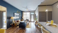 This thoughtfully designed single-floor residence in Smyrna, Tennessee offers a cohesive blend of modern style and functional living. The open-concept living area makes a strong first impression with rich hardwood-style flooring, a bold teal accent wall, large windows that flood the space with natural light, and a ceiling fan overhead. The living room flows seamlessly into a dedicated dining nook, distinguished by a deep navy accent wall, a round mirror, and direct sightlines to the kitchen.

The kitchen is well-appointed with white shaker cabinetry, granite-style countertops, a classic subway tile backsplash, and a full suite of stainless steel appliances including a refrigerator, range, microwave, and dishwasher. A breakfast bar island with pendant lighting provides additional seating and prep space.

Two bedrooms offer a comfortable retreat, each featuring plush carpet, ceiling fans, and large windows with outdoor views. The primary bathroom includes a glass-enclosed walk-in shower with white tile surround and wood-style flooring. The second bathroom features a full tub-shower combo, a granite-top vanity, and matching flooring, maintaining a consistent, polished aesthetic throughout the home.
