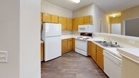 This single-floor, 3-bedroom, 2-bathroom home in Hickory, NC offers a well-organized and functional layout suited for everyday living. The living room serves as the centerpiece of the home, featuring a classic fireplace with a decorative white mantel and built-in shelving niche, plush carpeting, a ceiling fan, and a private exterior door that invites natural light. The kitchen is equipped with warm oak cabinetry, ample counter space, and white appliances including a range, microwave, refrigerator, and dishwasher, all set atop durable wood-look flooring. The primary bedroom is generously sized and provides direct access to both a closet and a full bathroom, lending a private suite feel. Two additional bedrooms feature plush carpeting and windows that bring in natural light, offering comfortable spaces for rest or flexible use. Both bathrooms are finished with wood-look flooring, warm wood vanities, and full tub-shower combinations. The dedicated laundry room includes wire shelving and hookups for a washer and dryer. Neutral tones and textured ceilings are consistent throughout, creating a cohesive and move-in-ready environment.