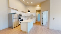 Located at 3539 Landview Dr SE in Olympia, WA, this single-story, 3-bedroom, 1-bathroom home offers a thoughtfully designed layout with clean, modern finishes throughout. The open-concept kitchen and living area is a standout feature, boasting dramatically high ceilings, recessed lighting, and a sleek pendant light over a central island with white quartz countertops. The kitchen is outfitted with white shaker-style cabinetry with matte black hardware, stainless steel appliances including a refrigerator, range, and over-the-range microwave, and a stainless undermount sink. Light wood-look flooring runs throughout the entire home, creating a cohesive, airy feel. The primary bedroom features soaring ceilings, a ceiling fan, and multiple windows that flood the room with natural light and offer views of the surrounding neighborhood. The additional bedrooms are well-proportioned, each with windows providing natural light and outdoor views. The bathroom includes a wide vanity with white cabinetry, a large mirror, and a full tub-shower combination. A dedicated laundry room houses a full-size washer and dryer with built-in shelving above. A sliding glass door in the living area opens to an outdoor balcony, further enhancing the home's bright and welcoming ambiance.