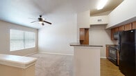 Located at 4649 Loma del Sur Dr in El Paso, TX, this 2-bedroom, 1-bathroom single-story unit offers a well-organized and functional layout across its single floor. The open-concept living and dining area is finished with plush carpet and features a ceiling fan with light, creating a comfortable and airy atmosphere. Natural light filters in through windows fitted with blinds.

The kitchen flows seamlessly from the main living area, separated by a breakfast bar with a dark granite-style countertop. Warm wood-toned cabinetry, hardwood-style flooring, and black appliances — including a refrigerator and range — complete the space efficiently.

Both bedrooms are carpeted and include ceiling fans, with windows allowing in natural light. The primary bedroom benefits from a generous walk-in closet outfitted with dual hanging rods, built-in shelving, and a central shelving tower, offering ample organized storage. A second closet provides additional space.

The bathroom includes a full tub and shower combination with built-in wall niches. A dedicated laundry room with hardwood-style flooring features washer and dryer hookups, offering added in-unit convenience. A hallway connects the private areas of the home, completing this practical and neatly arranged floor plan.