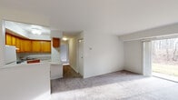 Located at 6718 Havenoak Rd in Rosedale, Maryland, this single-floor unit offers a practical and well-organized layout designed for comfortable everyday living. The living area is generously proportioned, featuring neutral-toned carpet underfoot and a full-width sliding glass door that floods the space with natural light and provides direct views of the surrounding wooded landscape, creating a peaceful, nature-connected ambiance throughout.

The kitchen is positioned adjacent to the living area and is equipped with warm honey-toned wood cabinetry extending along two walls, offering ample storage. White appliances including a gas range, refrigerator, and built-in sink complement the light countertops, while hardwood-style flooring adds a clean, durable finish to the space.

The unit includes two carpeted bedrooms, each featuring windows that capture natural light and views of the tree-lined surroundings. One bedroom includes a walk-in closet and direct access to a full bathroom, while the second bedroom offers a built-in closet with a rod and shelf system. Two bathrooms serve the unit: one full bath with a tub-shower combination and tile surround, and a second bathroom featuring white subway tile wainscoting, a wood-trimmed vanity, and hardwood-style flooring.