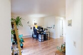 This efficiently designed 1-bedroom, 1-bathroom residence makes excellent use of its single-floor layout, offering a functional and comfortable living environment. The entrance opens into a spacious main living area finished with warm light hardwood flooring that extends throughout the unit, creating a cohesive and inviting atmosphere.

The galley-style kitchen is thoughtfully designed with light wood cabinetry, black appliances including a full-size refrigerator and range, and a pass-through counter that connects seamlessly to the adjoining dining area. The dining room comfortably accommodates a four-seat wooden table and is brightened by a ceiling fan overhead. From here, an open view into the main living space provides a generous, connected feel.

The bedroom is a well-proportioned private retreat, featuring a ceiling fan with light fixture, a window that brings in natural light, and hardwood flooring underfoot. A dedicated closet offers practical storage.

The bathroom is finished with tile flooring and includes a vanity with wood cabinetry and a countertop sink. Clean white walls throughout the unit contribute to a bright, neutral backdrop. Baseboard heating is present in multiple rooms, ensuring year-round comfort. Overall, this residence offers a practical and livable single-floor layout with consistent finishes and a functional room configuration.