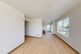Located at 16224 Meadow Rd in Lynnwood, WA, this well-appointed single-floor residence offers three bedrooms, three bathrooms, and a thoughtfully designed layout. Light wood-style flooring flows throughout the main living areas, creating a bright and cohesive aesthetic. The open-concept kitchen and living room serve as the heart of the home, featuring dark espresso cabinetry, a crisp white quartz island, subway tile backsplash, stainless steel appliances including a range, dishwasher, and refrigerator, and pendant lighting complemented by track lighting above. Large windows in the living area invite generous natural light and frame views of the surrounding Lynnwood neighborhood. The spacious primary bedroom includes an en suite bathroom with a dual-sink vanity, white quartz countertops, dark cabinetry, and a glass-enclosed walk-in shower, as well as ample closet space. The additional bedrooms feature plush carpeting, ceiling fans, and corner windows offering pleasant outdoor views. With five closets, an in-unit laundry area, a patio, and a connecting hallway, this residence balances practical storage and comfortable living in a clean, modern design.