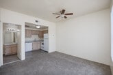 Located at 600 West 12th Street in Yuma, Arizona, this one-bedroom, one-bathroom unit offers a practical and well-organized single-floor layout. The living room is carpeted and brightened by a large window with vertical blinds, and is equipped with a ceiling fan with light fixture to help manage Yuma's warm climate. It flows seamlessly into the kitchen, which features light wood cabinetry, laminate wood-style flooring, a full suite of white appliances including a refrigerator, range, and dishwasher, as well as a sink and ample counter space. The bedroom is a comfortable, carpeted retreat with its own large window dressed with vertical blinds, a ceiling fan, and access to two closets — one of which is a walk-in closet with built-in shelving and hanging rods, providing generous storage. The full bathroom is clean and functional, featuring a light wood vanity with a single sink, a large mirror, a bathtub/shower combination, and durable wood-style flooring. Neutral tones throughout the unit lend a bright, move-in-ready feel, making this a well-appointed space in Yuma's West Side neighborhood.