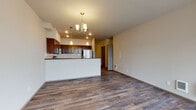This single-floor unit at 19112 East Alki Avenue in Spokane Valley, Washington, offers a thoughtfully designed layout with contemporary finishes throughout. The open-concept living and dining area is anchored by rich, wood-look plank flooring and illuminated by a decorative chandelier, creating a warm and inviting atmosphere. Large windows allow natural light to fill the space, with views of the surrounding neighborhood adding to its appeal.

The kitchen is a standout feature, showcasing dark espresso cabinetry, granite-style countertops, a classic subway tile backsplash, and a full suite of stainless steel appliances including a refrigerator, range, and built-in microwave. A breakfast bar provides convenient counter seating and separates the kitchen from the living area.

The bedrooms offer comfortable, carpeted flooring with natural light from well-placed windows, and include closets with built-in shelving and hanging rods for organized storage. Two bathrooms are finished with wood-look flooring, dark vanity cabinetry, and light countertops; one features a glass-enclosed shower, while the other includes a soaking tub. A dedicated laundry area houses a full-size washer and dryer, adding everyday convenience to this well-rounded space.