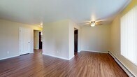Located at 1306 Sunfield St in Sun Prairie, Wisconsin, this single-floor residence offers a practical and well-appointed layout designed for comfortable everyday living. The main living area is finished with rich wood-look hardwood flooring and features a ceiling fan, creating a bright and airy atmosphere. French doors in the living space open to a view of the outdoors, filling the room with natural light and providing easy outdoor access. The galley-style kitchen is a standout feature, outfitted with dark espresso cabinetry, granite-look countertops, stainless steel appliances including a refrigerator, range, and dishwasher, along with a double sink — offering both style and functionality in an efficient layout. The bedrooms are carpeted for comfort and include generous closet space with sliding panel doors and built-in hanging rods. Baseboard heating is present throughout, ensuring warmth during Wisconsin winters. The bathroom is cleanly appointed with a dark wood vanity, white countertop, a full tub and shower combination, and wood-look flooring that ties cohesively to the rest of the home. Neutral wall tones throughout the space create a versatile backdrop suitable for a variety of interior styles.