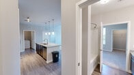 Located in Parker, Colorado, this well-appointed 2-bedroom, 2-bathroom residence offers a thoughtfully designed single-level layout with modern finishes throughout. The open-concept kitchen serves as the heart of the home, showcasing a large granite-topped island with an undermount sink, dark espresso cabinetry, a white subway tile backsplash, and a full suite of stainless steel appliances including a French door refrigerator, electric range, and microwave. Stylish pendant lighting illuminates the island, while hardwood-style flooring flows throughout the main living and kitchen areas. The spacious primary bedroom features soft carpeting, a ceiling fan, and a window that welcomes natural light and outdoor views. Its en-suite bathroom is appointed with granite countertops, dark cabinetry, a tub-shower combination, and wood-style flooring. The second bathroom mirrors this refined aesthetic. Carpeted bedrooms offer a comfortable, quiet retreat. A dedicated laundry room provides added convenience with space for a full-size washer and dryer. The clean, neutral color palette and consistent finishes create a cohesive, move-in-ready atmosphere throughout this well-organized Parker home.