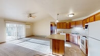 Located at 1415 Silverstone Trl in De Pere, Wisconsin, this well-appointed two-bedroom, two-bathroom residence offers a comfortable and functional single-floor layout. The open-concept living and kitchen area forms the heart of the home, featuring vaulted ceilings with a ceiling fan, plush carpeting in the living space, and sliding glass doors that flood the room with natural light and provide outdoor views. A large picture window further enhances the bright, airy atmosphere.

The kitchen is thoughtfully designed with warm honey-toned wood cabinetry, generous counter space, a central island with additional prep area, tile flooring, and a full suite of white appliances including a dishwasher, range, built-in microwave, and refrigerator. Pendant lighting adds a finished touch above the island.

Both bedrooms are carpeted and comfortably sized, with the primary bedroom offering a spacious walk-in closet featuring built-in shelving and hanging rods. The second bedroom includes a sliding-door closet. Each bathroom is finished with tile flooring and a tub-shower combination, and a conveniently located in-unit washer and dryer adds everyday practicality. The hallway connects all areas seamlessly, creating a cohesive and efficient floor plan throughout.