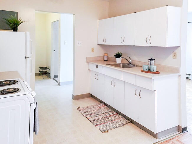 Découvrez la commodité d'une cuisine bien équipée avec beaucoup d'espace de rangement et de comptoir aux appartements 1025 Munroe. - 1025 Munroe Avenue