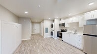 This 400 square foot studio apartment in Bend, Oregon, showcases a thoughtful blend of compact living and modern amenities. The open-concept design maximizes the use of space, creating a seamless flow between the living area, kitchen, and sleeping space. The living area is anchored by a sleek gas fireplace with a tiled surround, adding both warmth and visual interest.

The kitchen boasts contemporary white cabinetry, stainless steel appliances, and ample counter space, making it both functional and aesthetically pleasing. A full-size refrigerator, built-in microwave, and electric range provide all the necessities for preparing meals.

One of the standout features is the in-unit laundry, with a stacked washer and dryer conveniently tucked into the kitchen area. The bathroom is well-appointed with a modern vanity, large mirror, and stylish fixtures.

Throughout the apartment, recessed lighting and a ceiling fan contribute to the bright, airy atmosphere. The neutral color palette and light wood-look flooring create a sense of spaciousness and allow for personal decorating touches. Large windows provide natural light and views of the surrounding area.

Despite its compact size, this studio apartment offers efficient storage solutions, including built-in closets and cabinets. The overall design demonstrates how small-space living can be both comfortable and stylish.