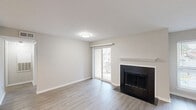Located at 3340 Hampton Point Dr in Silver Spring, MD, this well-appointed one-bedroom, one-bathroom unit offers a thoughtfully designed single-floor layout. The open-concept living and kitchen area is anchored by a sleek fireplace with a white mantle and dark surround, complemented by light wood-tone laminate flooring throughout. A sliding glass door floods the living space with natural light and provides access to a private outdoor area. The kitchen is well-equipped with warm honey-toned cabinetry, granite countertops, a subway tile backsplash, and a full suite of stainless steel appliances including a refrigerator, range, and over-the-range microwave. A sliding pantry door adds convenient storage. The bedroom offers comfortable carpeted flooring, a ceiling fan with light fixture, and a window with outdoor views, creating a calm and restful retreat. The full bathroom features a tub-shower combo with white tile surround, a vanity with granite countertop and a framed mirror, and light wood-tone flooring. A dedicated closet and hallway round out the functional layout, making efficient use of the available space throughout.