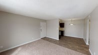 Located at 101 E 88th Ave in Thornton, Colorado, this single-floor unit offers a practical and well-appointed layout designed for comfortable everyday living. The open living and dining area is finished with warm neutral-toned carpet that transitions seamlessly into durable wood-look plank flooring throughout the kitchen and hallway spaces. A sliding glass door in the living area floods the room with natural light and opens to a private balcony, providing an inviting outdoor retreat.

The galley-style kitchen is well-equipped, featuring rich dark espresso cabinetry that extends floor to ceiling on both sides, light granite-style countertops, a stainless steel sink, and black appliances including a range and refrigerator. A pendant light fixture anchors the adjacent dining nook, creating a defined and functional eating area.

The bedroom is a quiet, carpeted space with a window dressed with blinds, offering natural light and a sense of openness. The full bathroom includes a tiled tub and shower surround in warm earth tones, wood-look plank flooring, a granite-topped vanity with dark cabinetry, and a standard toilet. Textured ceilings and clean white baseboards throughout the unit contribute to a cohesive, move-in-ready aesthetic.