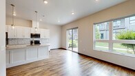 Located at 1073 Blazing Star Blvd in Altoona, Wisconsin, this two-story home offers 2 bedrooms and 3 bathrooms across two well-defined levels. The main floor houses the open-concept kitchen and living area, finished with warm wood-look luxury vinyl plank flooring throughout. The kitchen is equipped with white shaker cabinetry reaching to the ceiling, granite countertops, stainless steel appliances, a decorative tile backsplash, and a central island with pendant lighting and a built-in sink — ideal for both everyday cooking and entertaining. A sliding glass door brings in natural light and connects the living area to the outdoors. A half bathroom with granite vanity and dark-stained wood doors is also conveniently located on this floor. Upstairs, the two bedrooms are carpeted and feature ceiling fans and windows that allow natural light. The spacious primary bedroom includes access to a well-organized walk-in closet with built-in shelving and hanging rods. The bathrooms are finished with granite countertops, white cabinetry, wood-look flooring, and natural light from frosted windows. A dedicated laundry room on the upper level includes a full-size washer and dryer with overhead shelving for added storage. Dark wood trim and door accents provide a cohesive design element throughout the home.
