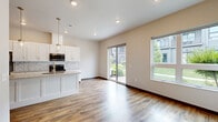 Located at 1073 Blazing Star Blvd in Altoona, Wisconsin, this two-story home offers 2 bedrooms and 3 bathrooms across two well-defined levels. The main floor houses the open-concept kitchen and living area, finished with warm wood-look luxury vinyl plank flooring throughout. The kitchen is equipped with white shaker cabinetry reaching to the ceiling, granite countertops, stainless steel appliances, a decorative tile backsplash, and a central island with pendant lighting and a built-in sink — ideal for both everyday cooking and entertaining. A sliding glass door brings in natural light and connects the living area to the outdoors. A half bathroom with granite vanity and dark-stained wood doors is also conveniently located on this floor. Upstairs, the two bedrooms are carpeted and feature ceiling fans and windows that allow natural light. The spacious primary bedroom includes access to a well-organized walk-in closet with built-in shelving and hanging rods. The bathrooms are finished with granite countertops, white cabinetry, wood-look flooring, and natural light from frosted windows. A dedicated laundry room on the upper level includes a full-size washer and dryer with overhead shelving for added storage. Dark wood trim and door accents provide a cohesive design element throughout the home.