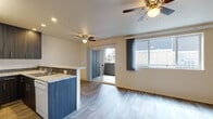 Located at 9603 NE Hazel Dell Ave in Vancouver, Washington, this single-floor unit offers a well-organized layout designed for comfortable everyday living. The kitchen is a standout feature, showcasing dark wood-tone cabinetry that extends to the ceiling for ample storage, granite-style countertops with a mosaic tile backsplash, a peninsula with a breakfast bar, and white appliances including a refrigerator, range, and dishwasher. Wood-style plank flooring runs throughout the kitchen and living areas, adding warmth and continuity.

The living area is open and airy, with a ceiling fan, sliding glass door leading to an outdoor patio, and a window that brings in natural light and outdoor views. A second room with wood-style flooring and a ceiling fan provides flexible use as a dining or additional living space.

Bedrooms are carpeted for comfort, each featuring ceiling fans and generous closets with built-in shelving and hanging rods. The unit includes two full bathrooms, both finished with granite-topped vanities, white cabinetry with brushed hardware, and wood-look tile flooring. One bathroom offers a tub-shower combination. A central hallway with closet storage connects the main living spaces, completing this thoughtfully designed, move-in-ready unit.