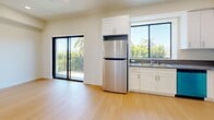 Located on Weddington Street in the heart of Los Angeles, this thoughtfully designed one-bedroom, one-bathroom unit offers a bright and modern living experience. Light-toned hardwood flooring runs throughout, lending warmth and cohesion to the entire space.

The open kitchen is well-appointed with white shaker cabinetry, gray countertops, and a full suite of stainless steel appliances including a refrigerator, range, over-the-range microwave, and dishwasher. A large black-framed window above the sink floods the kitchen with natural light, while a sliding glass door opens directly onto a private balcony — a standout feature offering sweeping views of mature palm trees, lush greenery, and clear Southern California skies.

The bedroom is comfortably scaled, featuring a large window with leafy outdoor views, recessed lighting, and a mirrored sliding-door closet that enhances the sense of space. Clean white walls and recessed lighting maintain the unit's modern, minimalist aesthetic throughout.

The bathroom is clean and functional, featuring a tiled tub-shower combination with a sliding glass enclosure, built-in shelving, and light wood flooring. Every detail reflects a fresh, move-in-ready finish ideal for comfortable urban living in the San Fernando Valley.