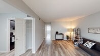 This 1-bedroom, 1-bathroom residence in Baton Rouge, Louisiana offers a clean, modern aesthetic across a thoughtfully designed single-floor layout. Light-toned wood-look flooring runs throughout the entire unit, creating a cohesive and easy-to-maintain foundation in every room.

The living area is generously sized, providing ample room for comfortable furnishings. Neutral gray walls and good natural light give the space an open, airy feel. A built-in closet with shelving is conveniently accessible from the living area, offering practical storage.

The galley-style kitchen is a standout feature, lined on both sides with dark navy shaker-style cabinetry and white countertops. Black appliances, including a refrigerator and electric range, complement the bold cabinetry, while a stainless steel sink adds a modern touch. A hallway connecting the kitchen to the rest of the unit adds to the efficient flow of the space.

The bedroom is a calm retreat with soft gray walls, a window with natural light, and a closet. The room easily accommodates a full-sized bed with space to spare.

The bathroom is clean and functional, featuring a single vanity with white countertop, a mirror, and a full shower-tub combination. The overall design of this unit prioritizes practicality and modern comfort.