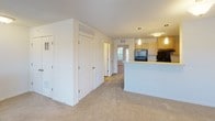 Located at 100 Sandbar Ct NE in Rochester, Minnesota, this single-floor unit offers a well-organized, open layout designed for comfortable everyday living. The floor plan reveals a cohesive arrangement of living, kitchen, and private spaces connected by wide, accessible corridors.

The living area is generously sized, featuring neutral carpet flooring, a ceiling fan with light fixture, and multiple windows alongside a glass patio door that fills the room with natural light and provides direct outdoor access. The bright, airy atmosphere makes the space feel open and inviting.

The kitchen is efficiently laid out with light maple cabinetry, ample counter space, a double stainless steel sink, and black appliances including a refrigerator and range. Hardwood-style flooring and pendant lighting over the peninsula add a functional yet polished character to the space.

A dedicated in-unit laundry room houses a full-size washer and dryer side by side, complemented by a shelf for storage and a window for ventilation. The bathroom features light maple vanity cabinetry, a single sink with mirror, hardwood-style flooring, and a separate shower and toilet area. Ample closet space is present throughout the unit, and the neutral color palette maintains a clean, cohesive aesthetic from room to room.