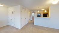 Located at 100 Sandbar Ct NE in Rochester, Minnesota, this single-floor unit offers a well-organized, open layout designed for comfortable everyday living. The floor plan reveals a cohesive arrangement of living, kitchen, and private spaces connected by wide, accessible corridors.

The living area is generously sized, featuring neutral carpet flooring, a ceiling fan with light fixture, and multiple windows alongside a glass patio door that fills the room with natural light and provides direct outdoor access. The bright, airy atmosphere makes the space feel open and inviting.

The kitchen is efficiently laid out with light maple cabinetry, ample counter space, a double stainless steel sink, and black appliances including a refrigerator and range. Hardwood-style flooring and pendant lighting over the peninsula add a functional yet polished character to the space.

A dedicated in-unit laundry room houses a full-size washer and dryer side by side, complemented by a shelf for storage and a window for ventilation. The bathroom features light maple vanity cabinetry, a single sink with mirror, hardwood-style flooring, and a separate shower and toilet area. Ample closet space is present throughout the unit, and the neutral color palette maintains a clean, cohesive aesthetic from room to room.