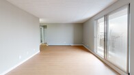 Located at 3445 Riverside Dr E in Windsor, Ontario, this one-bedroom, one-bathroom unit offers a well-organized layout across a single floor. The combined kitchen and living room forms the heart of the space, featuring light hardwood-style flooring, soft grey walls, and a tile-panel ceiling that runs throughout. The kitchen is designed with a galley-style configuration, offering white cabinetry extending to the ceiling, grey countertops, a stainless steel sink, and full-size stainless steel appliances including a refrigerator and stove. A sliding glass door in the living area leads to a private balcony, allowing natural light to fill the room. Baseboard heating units are present in both the living area and bedroom, ensuring year-round comfort. The bedroom is a comfortable, well-proportioned room with the same warm flooring, neutral walls, and a closet with a clean white door. The bathroom features a full tub-shower combination with white tile surround, grey countertop vanity, and tile flooring. A hallway connects the main rooms efficiently, completing this clean, functional, and move-in ready layout.