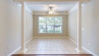 Located at 8115 Short Leaf Pine Cir in Greenville, SC, this well-appointed single-story home offers three bedrooms and two full bathrooms across a thoughtfully designed floor plan. The combined kitchen and dining area serves as a central hub, featuring light wood cabinetry, granite-style countertops, black appliances, a kitchen island with a built-in sink, and pendant lighting accented by crown molding — all set atop durable hardwood flooring. A decorative white column elegantly separates the dining space from the adjoining living area, where large windows invite generous natural light and outdoor views. The bedrooms are carpeted for comfort, each equipped with ceiling fans and windows that brighten the rooms with natural light. The spacious primary bedroom includes a walk-in closet outfitted with wire shelving systems, providing ample storage. A second walk-in closet is also available elsewhere in the home. The two bathrooms feature tub-shower combinations, warm wood vanities, and hardwood flooring. Neutral warm tones and consistent finishes throughout create a cohesive and inviting atmosphere. A hallway connects the bedroom wing to the main living areas, completing this functional and comfortable home layout.