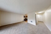 Located in Vancouver, WA, this one-bedroom, one-bathroom unit offers a practical and well-organized single-floor layout. The combined kitchen and living area forms the heart of the space, with the living room featuring wall-to-wall carpet, a textured ceiling, and a large sliding glass door fitted with vertical blinds that allows natural light to fill the room and provides views of the surrounding greenery. The kitchen is efficiently designed in a galley-style configuration, featuring rich dark-stained cabinetry, light stone countertops, wood-look flooring, and a full suite of stainless steel appliances including a refrigerator, dishwasher, and range. A carpeted hallway connects the main living area to the private bedroom, which is a generously sized room with a window offering natural light and a textured ceiling. A dedicated closet off the hallway provides added storage convenience. The bathroom is clean and functional, featuring wood-look flooring, a dark-stained vanity with a granite-style countertop, and a full tub-shower combination with brushed nickel fixtures. Throughout the unit, neutral tones and consistent finishes create a cohesive and practical living environment.