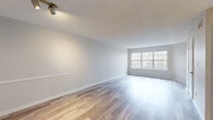 Located at 60 Glenbrook Rd in Stamford, Connecticut, this single-floor residence offers a clean, modern aesthetic throughout. The open-concept living area is finished with light hardwood-style flooring and neutral gray walls, creating a bright and welcoming atmosphere. A large window at the far end of the living space invites an abundance of natural light, while a track lighting fixture adds a contemporary touch overhead. The textured ceiling carries through the main living areas, adding subtle architectural detail.

The kitchen features a pass-through design with crisp white shaker-style cabinetry, light quartz countertops, and a full suite of stainless steel appliances, including a gas range, over-the-range microwave, and refrigerator. The layout provides efficient workspace and connects seamlessly to the main living area.

The bedroom is carpeted for comfort and includes a sliding glass door that opens to a private balcony with outdoor views, as well as access to a closet. The bathroom is neatly appointed with a full tub-shower combination, white cabinetry, and light tile flooring. Throughout the residence, white trim and neutral tones create a cohesive, move-in-ready environment ideal for comfortable everyday living.