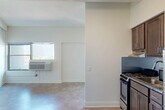 Located at 80 E Hancock St in Detroit's vibrant Midtown neighborhood, this efficiently designed studio unit offers a thoughtfully organized single-floor layout. The open-plan living and dining area provides a bright, clean environment anchored by light-toned flooring and crisp white walls, creating an airy feel despite the compact footprint. A window with a built-in wall AC unit allows natural light to filter in while offering views of the surrounding urban streetscape.

The kitchen is separated from the living area by a partial wall partition, offering a sense of defined space. It features warm, medium-toned brown cabinetry, granite countertops, a subway tile backsplash, a stainless steel gas range, and a sink — providing all the essentials for everyday cooking.

The full bathroom is cleanly finished with a granite-topped vanity with an undermount sink, a mirrored medicine cabinet, and a full soaking tub with a shower, accented by a grab bar for added accessibility. A dedicated closet space with a visible electrical panel offers practical storage and utility access.

Throughout the unit, consistent neutral tones and clean finishes contribute to a cohesive, functional aesthetic well-suited to urban living in one of Detroit's most walkable and culturally rich neighborhoods.