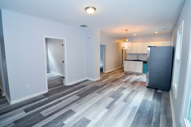 Main area looking into the kitchen. Doorways from left to right are bedrooms 2, 3, and 4. - 689 Winchester Ave