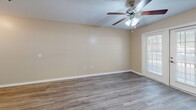 Located at 2611 Bemiss Rd in Valdosta, Georgia, this one-bedroom, one-bathroom unit offers a functional and well-maintained single-floor layout. Throughout the space, wood-style laminate flooring provides a cohesive, clean aesthetic complemented by neutral beige walls and textured ceilings.

The combined kitchen and living area serves as the heart of the unit. The kitchen features white cabinetry, ample counter space, a peninsula with a breakfast bar overhang, and white appliances including a refrigerator and range. The living area is bright and open, equipped with a ceiling fan and light fixture, and accented by French doors that allow natural light to fill the room and provide access to the outdoors.

The bedroom is a comfortable size, featuring its own ceiling fan, a closet with bifold doors, and a window that brings in natural light with views of surrounding greenery. The room's warm wood-tone flooring adds to its inviting atmosphere.

The bathroom is thoughtfully designed with accessibility in mind, featuring grab bars in the tub/shower combination, a wall-mounted vanity with a large mirror and vanity lighting, and continued wood-style flooring. A dedicated closet provides additional storage within the unit. Overall, this space offers a clean, practical, and move-in ready environment.