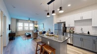 Located at 110 1 Mile Parkway in Nashville, TN, this thoughtfully designed one-bedroom, one-bathroom residence offers a smart and efficient single-floor layout. The open-concept living and kitchen area serves as the heart of the home, where light wood-style flooring, recessed lighting, and a neutral color palette create a clean, modern aesthetic.

The kitchen is a standout feature, showcasing two-tone cabinetry with white upper cabinets and gray lower cabinets, granite countertops, a subway tile backsplash, and a full suite of stainless steel appliances. A central island with a granite top and pendant lighting above provides additional workspace and casual seating. A dedicated dining nook sits adjacent to the kitchen, ideal for everyday meals.

The living room is bright and welcoming, with multiple windows allowing ample natural light and a ceiling fan overhead. The spacious primary bedroom features plush carpet, generous natural light from shuttered windows, a ceiling fan, and a dedicated closet for storage.

The bathroom is finished with wood-look flooring, a granite-topped vanity with white cabinetry, and a full tub and shower combination with white tile surround. Every room reflects a cohesive, contemporary design sensibility well-suited for comfortable Nashville living.