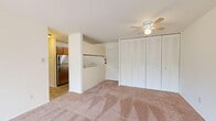 This well-organized one-bedroom, one-bathroom residence offers a practical and comfortable layout across a single floor. The combined kitchen and living area serves as the heart of the home, with the living space featuring neutral carpet flooring, a ceiling fan with integrated lighting, and a wall of louvered bi-fold closet doors for additional storage. A sliding glass door opens directly onto a private balcony, allowing natural light to fill the room and offering pleasant views of surrounding greenery.

The kitchen is efficiently designed with warm wood cabinetry, a double-basin stainless steel sink, light speckled countertops, and a gas range — providing ample functionality for everyday cooking.

The bedroom is a comfortable, carpeted retreat equipped with its own ceiling fan and a built-in closet. It connects to a dedicated walk-in closet that features multiple shelving levels on both sides, offering generous storage space.

The bathroom is finished with classic tile work in the tub-shower surround, mosaic tile flooring, a vanity with wood cabinetry, and a large mirror. The space is clean and functional throughout, maintaining a consistent neutral color palette that lends a bright, airy feel to every room.