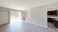 Located at 312 Shipley Rd in Wilmington, Delaware, this single-floor residence offers a clean, contemporary interior with a neutral color palette throughout. The open living area is highlighted by light gray hardwood-style flooring, a ceiling fan, and a large sliding glass door with vertical blinds that floods the space with natural light and provides direct views of the outdoors. The kitchen is well-equipped with rich dark wood cabinetry, marble-style countertops, a stainless steel double-basin sink, and a stylish mosaic tile backsplash that adds a decorative touch. The bedrooms feature soft wall-to-wall carpeting and are served by windows fitted with horizontal blinds, ensuring comfortable privacy and natural illumination. Multiple bedrooms are present, with one notably spacious room boasting dual windows for enhanced light. Two bathrooms are visible throughout the space; one includes white subway tile wainscoting, a vanity with a medicine cabinet mirror, and hardwood-style flooring, while the second is equally clean and bright with white tile accents. The overall layout is open and functional, with consistent warm-toned walls and white trim providing a cohesive, move-in-ready aesthetic throughout.