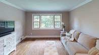 Located at 18 Engle St, Unit 11U in Tenafly, NJ, this single-floor one-bedroom, one-bathroom residence combines classic architectural details with comfortable, functional living. Throughout the unit, rich hardwood flooring and crisp crown molding create a polished, cohesive aesthetic.

The living room is a welcoming retreat, featuring a large triple-pane window framing lush green tree views that fill the space with abundant natural light. Warm, neutral-toned walls complement the wood floors and provide a versatile backdrop for a variety of décor styles.

The kitchen is thoughtfully equipped with rich wood cabinetry, granite countertops, a stainless steel sink, and a full suite of stainless steel appliances including a gas range, over-the-range microwave, and dishwasher. A window above the sink brings in natural light and garden views.

The bedroom is a serene and spacious retreat, featuring two windows with leafy outdoor views, hardwood flooring, and elegant crown molding. The neutral palette and natural light lend the room a calm, restful ambiance.

The bathroom is finished with large-format stone-look tile surrounding the tub and shower area, accented by a frosted glass window that provides both privacy and soft natural light. The overall design of this residence balances timeless finishes with everyday comfort.