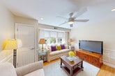 Located at 141 Chestnut St in Needham, MA, this well-appointed two-bedroom, one-bathroom residence offers a thoughtfully designed single-floor layout. Warm hardwood flooring flows throughout, complemented by neutral tones and classic wainscoting that lend a polished, cohesive aesthetic.

The bright living room features a ceiling fan, natural light from multiple windows, and connects seamlessly to a dedicated dining area. A pass-through window links the dining space to the kitchen, which is equipped with white shaker-style cabinetry, dark granite countertops, a tile backsplash, and stainless steel appliances — making efficient use of its compact footprint.

The spacious primary bedroom offers dual windows that invite natural light, a ceiling fan, and ample room for full-sized furnishings. The second bedroom is similarly well-lit and versatile. An impressively generous five closets are distributed throughout the unit, providing exceptional storage. The full bathroom features tile flooring and a shower/tub combination.

A connecting hallway with wainscoting ties the rooms together, maintaining the home's refined character. The overall ambiance is warm, bright, and functional — ideal for comfortable everyday living in a residential Needham setting.