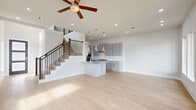 Located in Richmond, TX, this two-story home offers 3 bedrooms, 4 bathrooms, and a thoughtfully designed layout spread across two floors. The ground floor hosts the main living and entertaining areas, including an open kitchen and living room bathed in natural light from large windows that overlook the outdoors. The galley-style kitchen is well-appointed with gray shaker cabinetry, granite countertops, stainless steel appliances including a French door refrigerator, double wall oven, and a gas cooktop — all complemented by light hardwood-style flooring that flows throughout the home. The living area features recessed lighting, a ceiling fan, and direct access to an outdoor balcony through glass-paneled doors. The upper floor houses all three bedrooms, including a generously sized primary suite with a walk-in closet featuring built-in shelving and rods. The primary bathroom is finished with a dual-sink vanity, light gray cabinetry, white quartz countertops, and a full walk-in shower with large-format tile surround. A dedicated laundry room with side-by-side washer and dryer is also located on this level. The staircase features a classic dark wood and black metal railing. An attached garage with direct interior access completes the home.