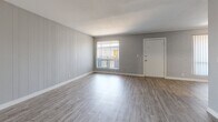 Located at 2925 N Greenfield Rd in Phoenix, Arizona, this 2-bedroom, 1-bathroom unit offers a well-organized single-floor layout designed for comfortable everyday living. Consistent light-toned luxury vinyl plank flooring runs throughout the space, tying the rooms together with a clean, modern aesthetic. Neutral gray walls and crisp white trim create a bright, cohesive palette.

The living room is a standout feature, showcasing a full accent wall with painted vertical shiplap paneling that adds texture and character. A large window with vertical blinds allows natural light to fill the room, while a secondary window provides views to an outdoor balcony area. The open layout transitions smoothly into the kitchen, which includes standard appliances and ample counter space.

Both bedrooms offer generous proportions, with the primary bedroom providing comfortable square footage for a full furniture arrangement. Each bedroom includes a closet — one featuring sliding doors and another with a standard hinged-door closet — offering practical storage solutions. The bedrooms are accented by painted brick walls and windows that bring in natural light.

The bathroom is finished in a clean, all-white palette with a tub-shower combination and wood-look flooring that continues the home's unified design. Overall, this unit presents a refreshed, move-in-ready interior with consistent finishes throughout.