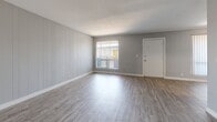 Located at 2925 N Greenfield Rd in Phoenix, Arizona, this 2-bedroom, 1-bathroom unit offers a well-organized single-floor layout designed for comfortable everyday living. Consistent light-toned luxury vinyl plank flooring runs throughout the space, tying the rooms together with a clean, modern aesthetic. Neutral gray walls and crisp white trim create a bright, cohesive palette.

The living room is a standout feature, showcasing a full accent wall with painted vertical shiplap paneling that adds texture and character. A large window with vertical blinds allows natural light to fill the room, while a secondary window provides views to an outdoor balcony area. The open layout transitions smoothly into the kitchen, which includes standard appliances and ample counter space.

Both bedrooms offer generous proportions, with the primary bedroom providing comfortable square footage for a full furniture arrangement. Each bedroom includes a closet — one featuring sliding doors and another with a standard hinged-door closet — offering practical storage solutions. The bedrooms are accented by painted brick walls and windows that bring in natural light.

The bathroom is finished in a clean, all-white palette with a tub-shower combination and wood-look flooring that continues the home's unified design. Overall, this unit presents a refreshed, move-in-ready interior with consistent finishes throughout.