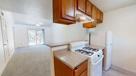 Located at 2950 W Portage Bay Ave in Davis, CA, this 2-bedroom, 1-bathroom unit offers a well-organized single-floor layout designed for comfortable everyday living. The living area is a standout feature, boasting soaring vaulted ceilings with a ceiling fan and a skylight that floods the space with natural light. A sliding glass door opens to an outdoor view, enhancing the open, airy feel of the room. Soft carpeting runs throughout the living area and both bedrooms, adding warmth underfoot.

The galley-style kitchen is efficiently laid out with rich warm-toned wood cabinetry on both sides, granite-style countertops, a gas range, refrigerator, dishwasher, and a window that brings in natural light. A pass-through counter connects the kitchen to the living area.

The primary bedroom is generously sized with its own window and a dedicated closet, while the second bedroom is equally bright with a window overlooking the exterior. A walk-in closet with dual hanging rods provides ample storage. The bathroom features warm wood cabinetry, a granite-style vanity countertop, and a tub-shower combination. Light wood-style flooring runs through the bathroom and hallway, tying the space together cohesively.