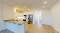 Located at 101 Alaina Avenue in Spring Hill, Tennessee, this two-story home offers three bedrooms, two bathrooms, and a well-designed layout spread across two floors. The main level welcomes you through a dedicated entrance that opens into a bright hallway leading to the open-concept kitchen, dining, and living areas. The kitchen is a standout feature, showcasing white shaker-style cabinetry, granite countertops with an undermount sink, a center island, and a full suite of stainless steel appliances. Light wood-style flooring flows throughout the main level, complementing the clean, neutral palette. A pantry and convenient garage access round out the first floor. The attached garage features a motorized door opener and polished concrete flooring. Upstairs, the spacious primary bedroom includes a walk-in closet and an en-suite bathroom with marble-style tile flooring, a walk-in glass shower, and a white vanity. Two additional bedrooms, each with natural light and closet space, share the second floor alongside a dedicated laundry room equipped with a full-size washer and dryer. A patio provides outdoor access, completing this thoughtfully laid-out home.