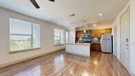 Located at 1160 Montgomery Boulevard in Allen, TX, this well-appointed one-bedroom, one-bathroom residence offers a thoughtfully designed open-concept layout. The combined living, dining, and kitchen area serves as the heart of the home, bathed in natural light from multiple large windows that offer views of the surrounding neighborhood. The kitchen is a standout, featuring warm wood cabinetry, granite countertops, a peninsula island with an undermount sink and pendant lighting, a tile backsplash, and a full suite of stainless steel appliances including a range, microwave, and refrigerator. Track lighting and recessed fixtures complete the kitchen's functional aesthetic. Hardwood-style flooring flows throughout the main living areas, adding warmth and continuity. The spacious bedroom is finished with plush carpeting, a ceiling fan, and generous windows that fill the room with natural light. Multiple closets, including a well-shelved walk-in, provide ample storage. The bathroom features wood-style flooring, dark cabinetry with granite counters, and a tiled tub-shower combination. Additional conveniences include an in-unit laundry area, a pantry, and a hallway connecting the private spaces seamlessly.