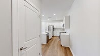 This thoughtfully designed one-bedroom, one-bathroom unit at 7600 Pennsy Pky offers a well-organized single-floor layout with modern finishes and a clean, neutral aesthetic. The open-concept kitchen and living area forms the heart of the home, where warm hardwood-style flooring flows throughout. The kitchen is a standout feature, boasting crisp white shaker cabinetry, light quartz countertops, a center island with an integrated sink, and a full suite of stainless steel appliances including a gas range, microwave, and refrigerator. Recessed lighting illuminates the space efficiently. The living area is bathed in natural light from a set of French doors that open to a private balcony, creating a seamless indoor-outdoor connection. The bedroom offers plush carpeting, a ceiling fan, a natural light-filled window, and a dedicated closet with double doors for ample storage. The bathroom is clean and functional, equipped with a full tub-shower combination featuring brushed nickel fixtures and a curved curtain rod. Throughout the unit, soft gray walls, white trim, and consistent flooring choices create a cohesive, move-in-ready environment well-suited for comfortable everyday living.